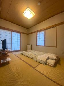 a bedroom with a bed and a tv in it at Crane in Kushiro