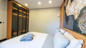 1 dormitorio con cama blanca y almohadas azules en Çimentepe Residence Deluxe, en Bodrum City