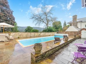 a swimming pool in a backyard with purple chairs and tables at The Coach House - Uk45027 in Gilwern
