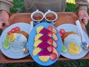 two plates of food with eggs and fruit on them at Rautani Sembalun in Sembalun Lawang