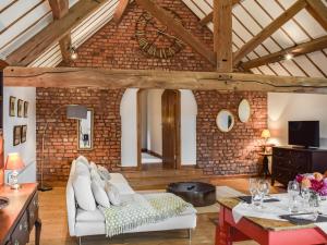 a living room with a white couch and a brick wall at The Barn in Nantwich