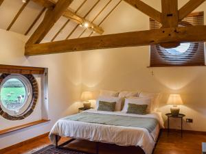 a bedroom with a bed and a large window at The Barn in Nantwich