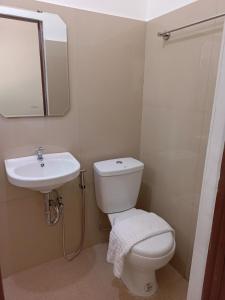 uma casa de banho com um WC branco e um lavatório. em Coco Bloom em Aborlan