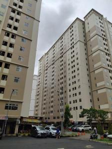 a large building with cars parked in a parking lot at Apartemen kalibata city By Alia Property in Jakarta