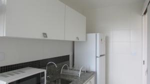 a kitchen with white cabinets and a white refrigerator at 439 Barrabela in Rio de Janeiro