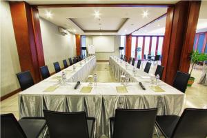 uma sala de conferências com uma mesa longa e cadeiras em Javein Griyadi Hotel em Jakarta
