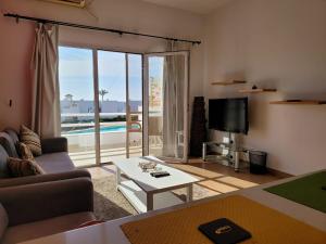ein Wohnzimmer mit einem Sofa, einem Tisch und einem TV in der Unterkunft Naama Bay resort in Sharm El Sheikh