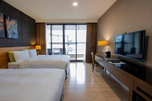 a hotel room with two beds and a flat screen tv at Lealea Garden Hotels - Sun Lake in Yuchi