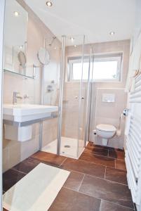 a bathroom with a shower and a sink and a toilet at Hotel Park in Sankt Johann in Tirol