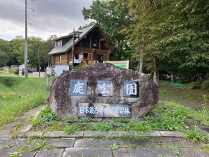 una roccia con sopra scritto di fronte a una casa di 落ち着きのある安らぎ空間／新千歳空港から30分の一棟貸し民家 a Chitose