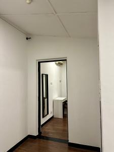 una habitación vacía con una pared blanca y un espejo en Hotel Arba, en Kuala Lumpur