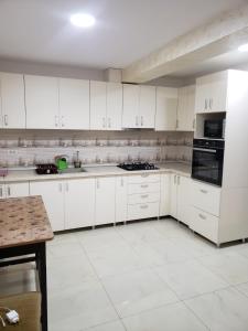 a white kitchen with white cabinets and appliances at Casa Nicoleta in Gura Humorului