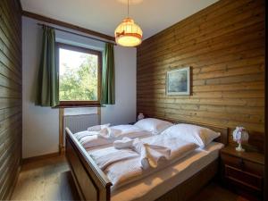 a bedroom with a large bed with a wooden wall at Apartment in Fresach near Millstättersee with pool in Fresach