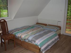 a bedroom with a bed and a chair and a window at Privat Mikyska in Terchová