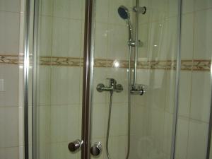 a shower with a glass door with a shower head at Privat Mikyska in Terchová