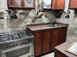 a kitchen with a stove and a sink at شقه ثلاثه غرف وريسبشن ثلاثه قطع لك بالكامل بها تكييف ف الصاله in Mansoura