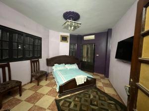 a bedroom with a bed and a flat screen tv at شقه ثلاثه غرف وريسبشن ثلاثه قطع لك بالكامل بها تكييف ف الصاله in Mansoura