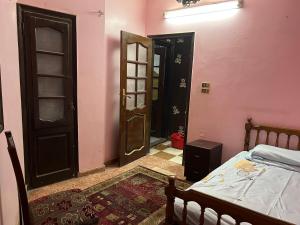 a bedroom with two doors and a bed and a rug at شقه ثلاثه غرف وريسبشن ثلاثه قطع لك بالكامل بها تكييف ف الصاله in Mansoura