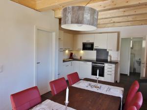 a kitchen with a table and red chairs in a room at Chalet in ski area in Koetschach-Mauthen in Kötschach