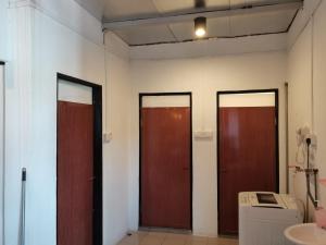 three doors in a room with a washing machine at Mac Inn 94 in George Town