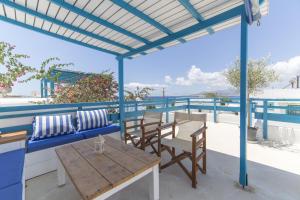 a patio with a table and chairs and the ocean at Astra Apartments in Agios Prokopios
