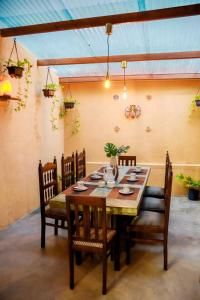 a dining room with a wooden table and chairs at The villaRo in Hikkaduwa