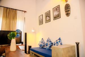 a living room with a blue couch and a tv at The villaRo in Hikkaduwa