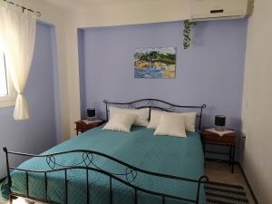 um quarto com uma cama com um edredão verde em Aspri Villa em Ammoudia