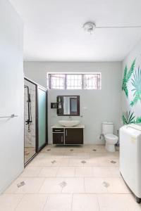 a white bathroom with a sink and a toilet at Spacious and Cosy Coastal Retreat in Albion