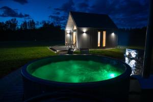 a hot tub in front of a tiny house at night at Atpūtas namiņš Laureta 