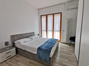 a bedroom with a bed and a large window at Casa Crisale in Alba