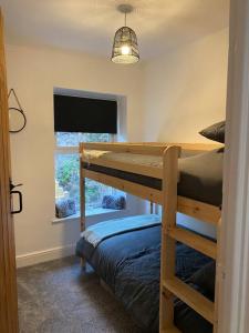 a bedroom with two bunk beds and a window at Quarryman’s Holiday Let in Llysfaen