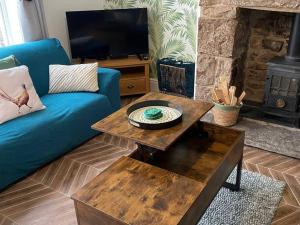 a living room with a blue couch and a fireplace at Quarryman’s Holiday Let in Llysfaen