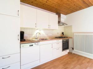 Comfortable Apartment in Thomatal near Ski Area في Thomatal: مطبخ بدولاب بيضاء وأرضية خشبية