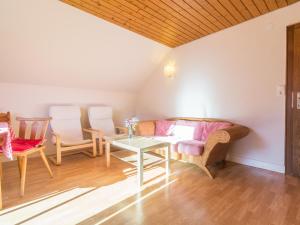 Comfortable Apartment in Thomatal near Ski Area في Thomatal: غرفة معيشة مع أريكة وكراسي وطاولة