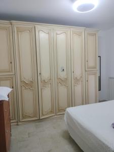 een slaapkamer met witte kasten en een bed erin bij Alloggio Maria in San Bartolomeo al Mare