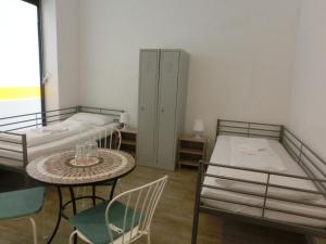 a room with two beds and a table and chairs at Pension Stadtpark in Hamburg