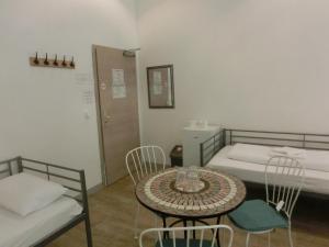 a room with two beds and a table and chairs at Pension Stadtpark in Hamburg