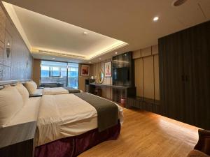 1 dormitorio con 1 cama grande en una habitación en Ming Zhi Hot Spring Hotel Building A, en Heping