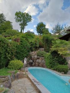 einen Pool in einem Garten mit einer Steinmauer in der Unterkunft Penthouse in the green with private pool and garden in Portula