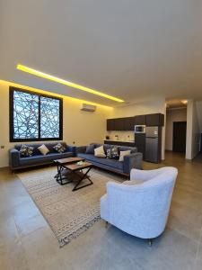 una gran sala de estar con sofás y una mesa. en فيلا جبل لبنان الهدا en Al Hada