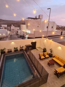 a swimming pool on the roof of a house with yellow furniture at فيلا جبل لبنان الهدا in Al Hada