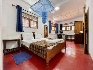 - une chambre avec un lit et un lustre bleu dans l'établissement SHADEY COTTAGE, à Gampola