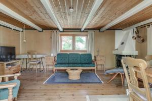 ein Wohnzimmer mit einem grünen Sofa und einem Tisch in der Unterkunft Cozy cottage by the lake, Charlottenberg in Åmotsfors