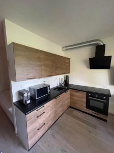 uma cozinha com armários de madeira e um balcão preto em Apartmán pod Jasanem Hojsova Stráž Brčálník em Železná Ruda