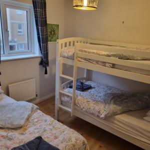 a bedroom with two bunk beds and a window at Driftmark Aberavon Beach The Crownlands 4 bedrooms Large Driveway parking 2 mins from Beach in Port Talbot
