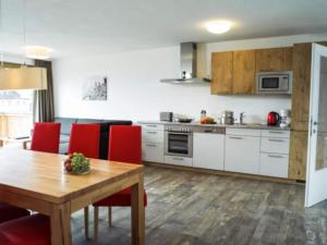 a kitchen with a wooden table and red chairs at Luxurious Apartment in Zell am See near Ski Area in Zell am See