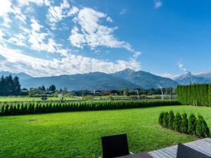 a laptop sitting on a bench in a field with mountains at Luxurious Apartment in Zell am See near Ski Area in Zell am See