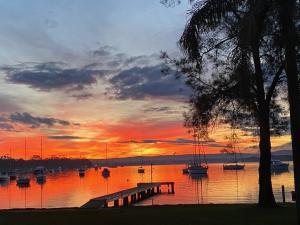 um pôr do sol sobre uma marina com barcos na água em Starfish Cottage em Cams Wharf