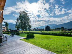 a wooden deck with a view of a field and mountains at Luxurious Apartment in Zell am See near Ski Area in Zell am See